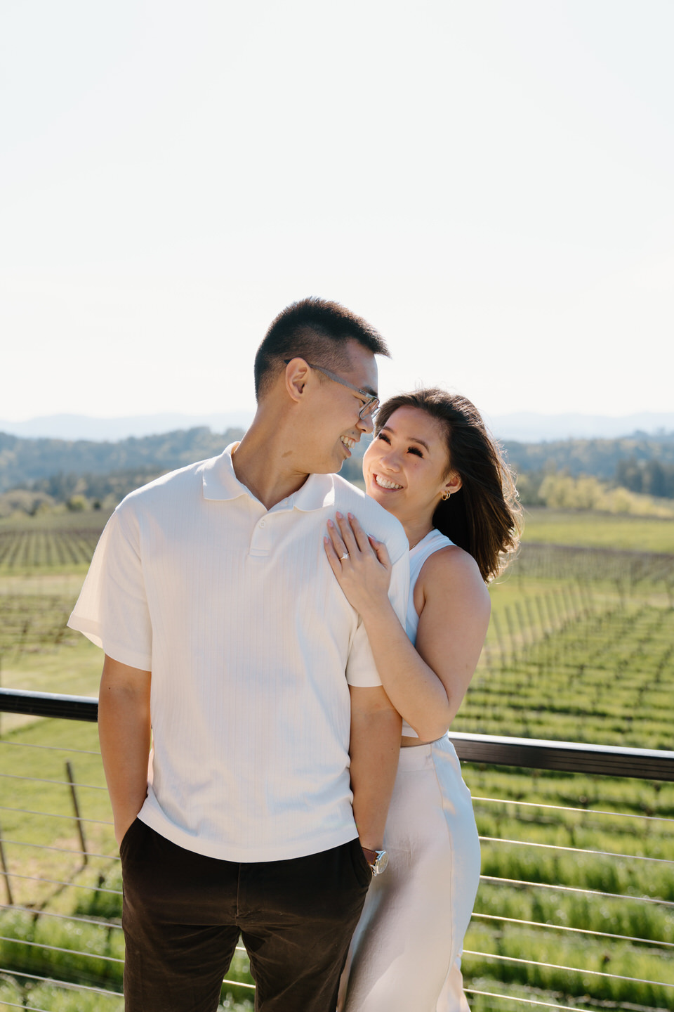 Oregon wine country proposal at Eminent Domaine winery with couple embracing among vineyard rows on a sunny April day.