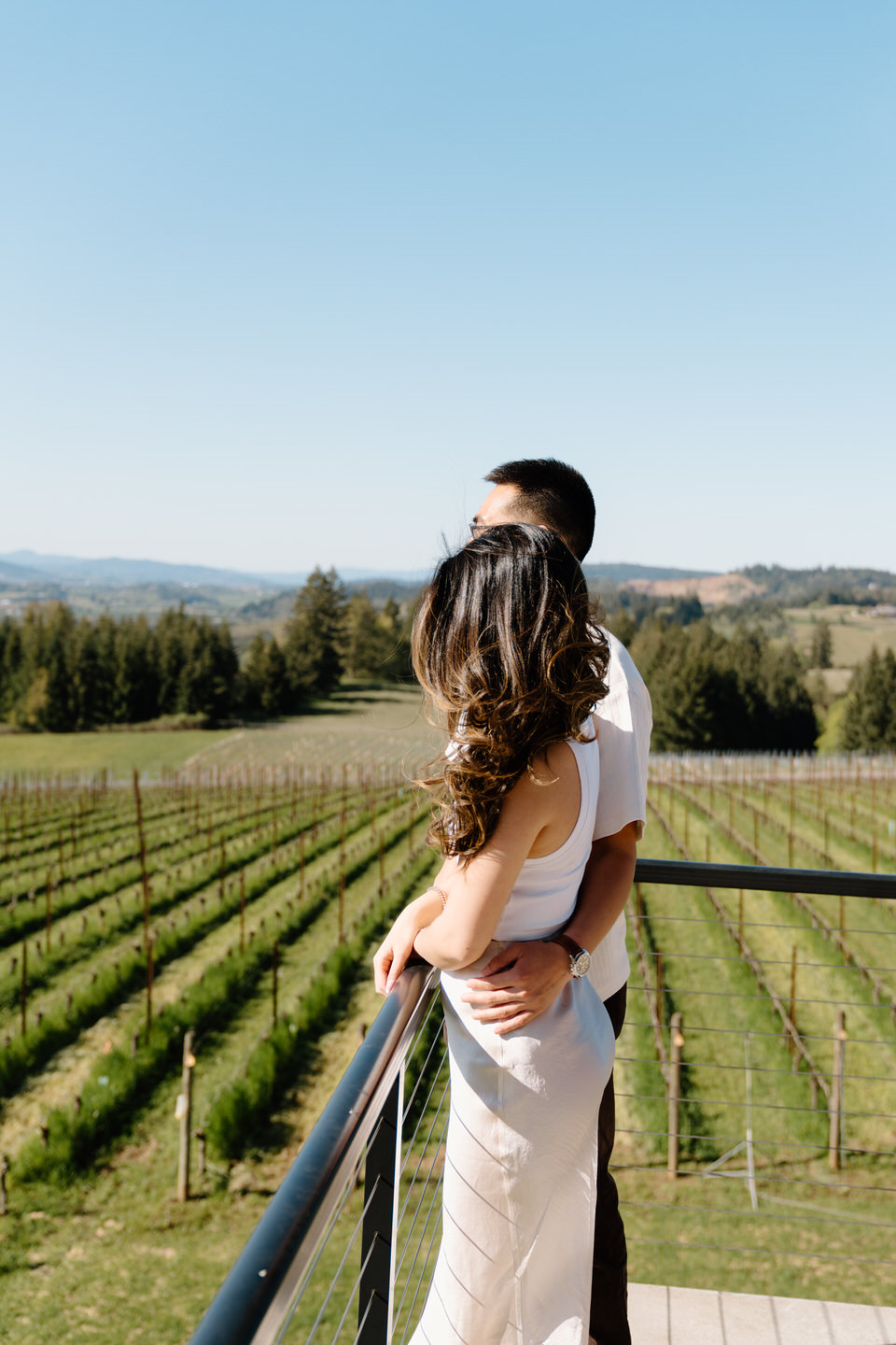 Oregon wine country proposal overlooking rolling vineyards at Eminent Domaine as couple shares a quiet, romantic moment.