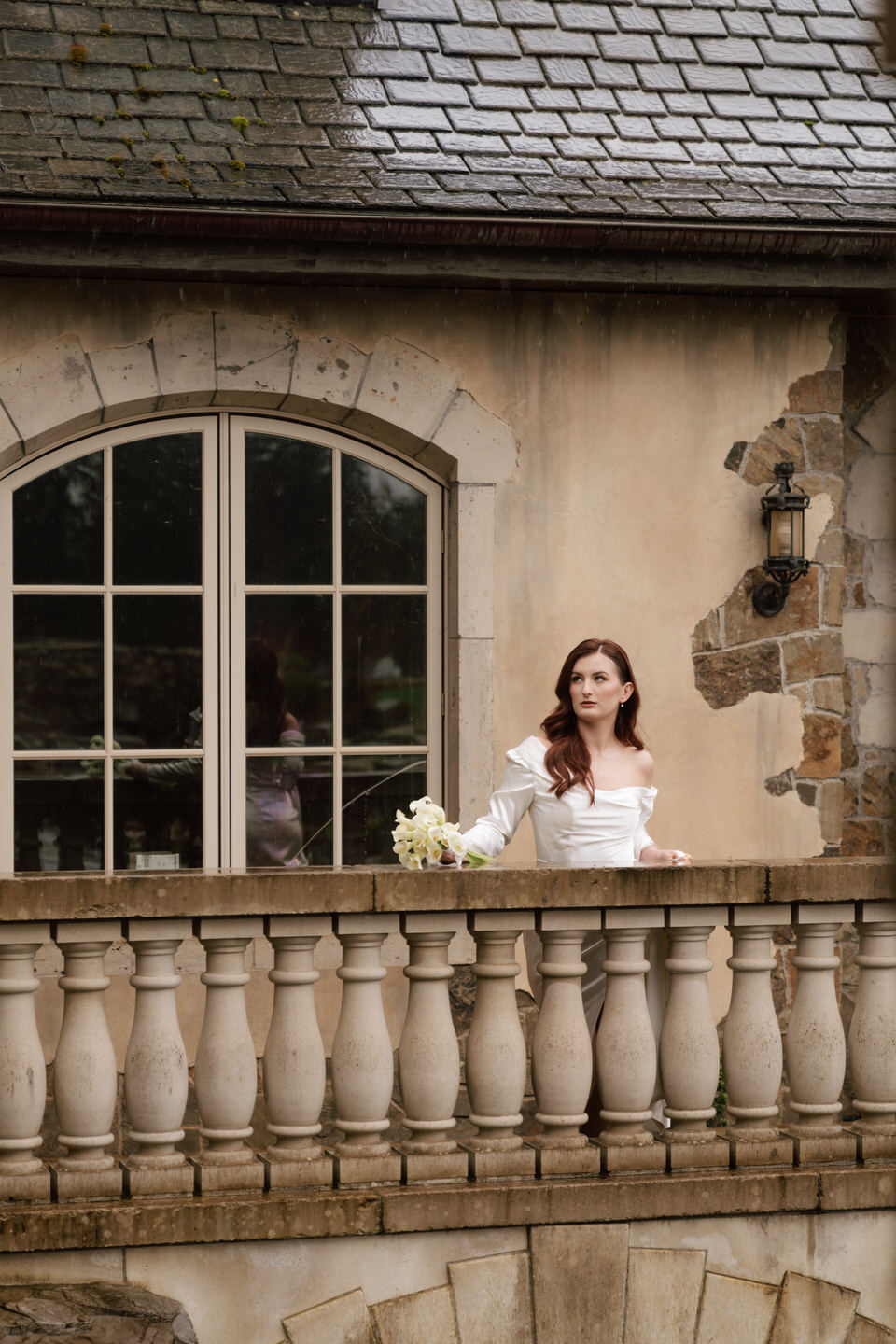 Woman with a calla lily bouquet poses on the bridge at Chateau de Lis.