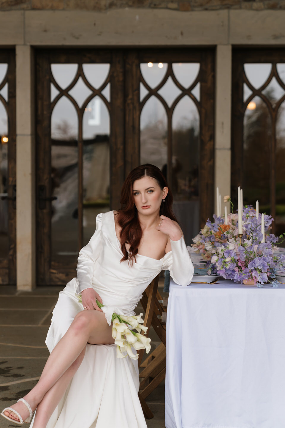 Bride poses at one of the wedding reception tables at Chateau de Lis.
