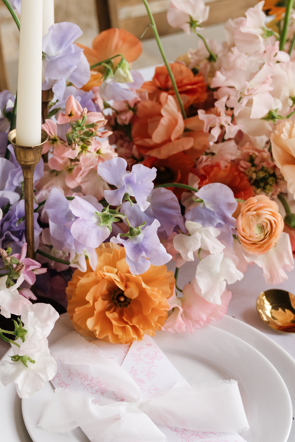Close-up of spring florals in peach, lavender, and blush tones styled for a luxury wedding.