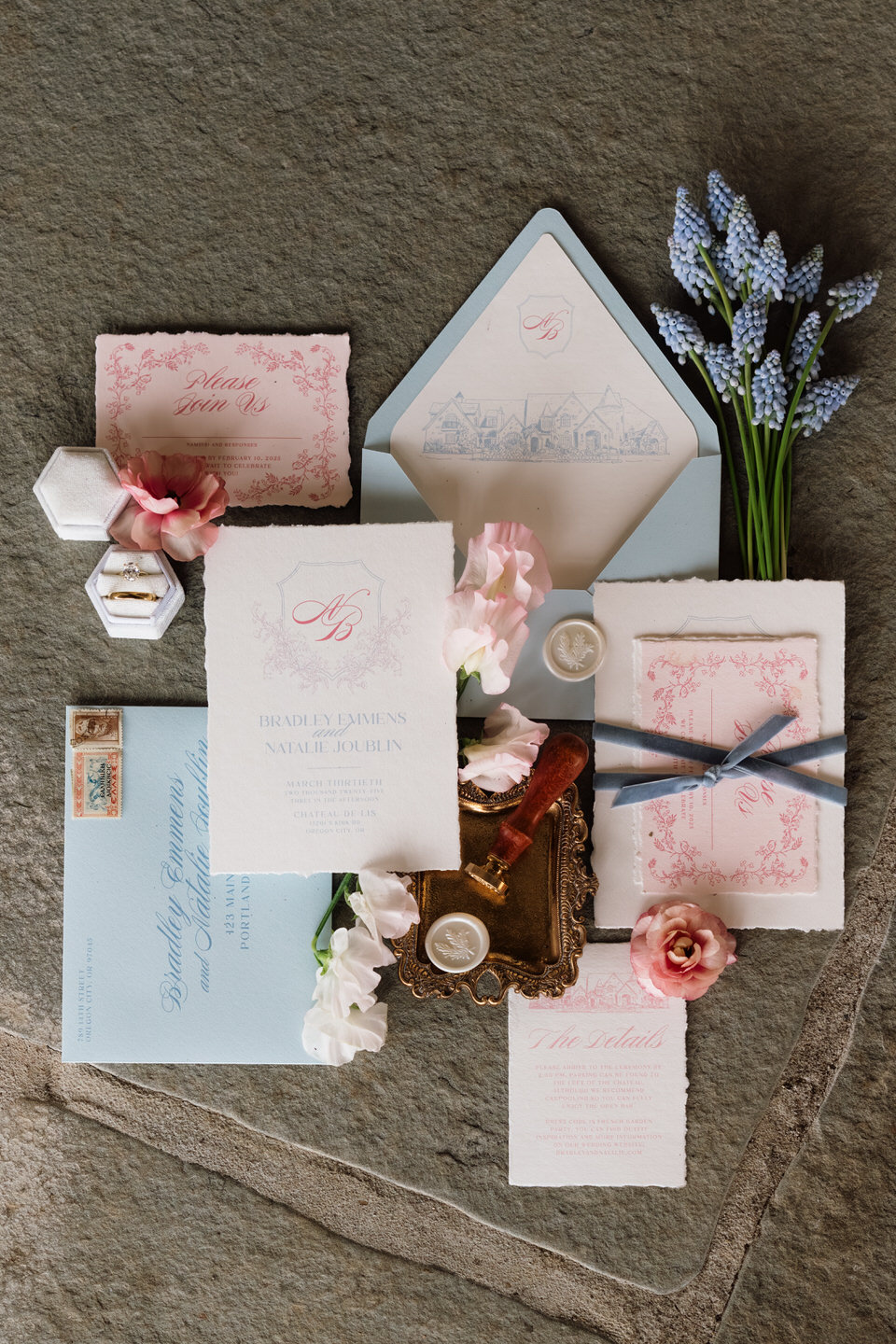 Flat lay of wedding paper goods, ribbons, and florals styled with soft spring color palette.