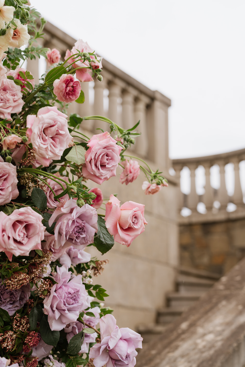 Ceremony aisle framed by florals at Chateau de Lis with stone steps and European garden elegance.