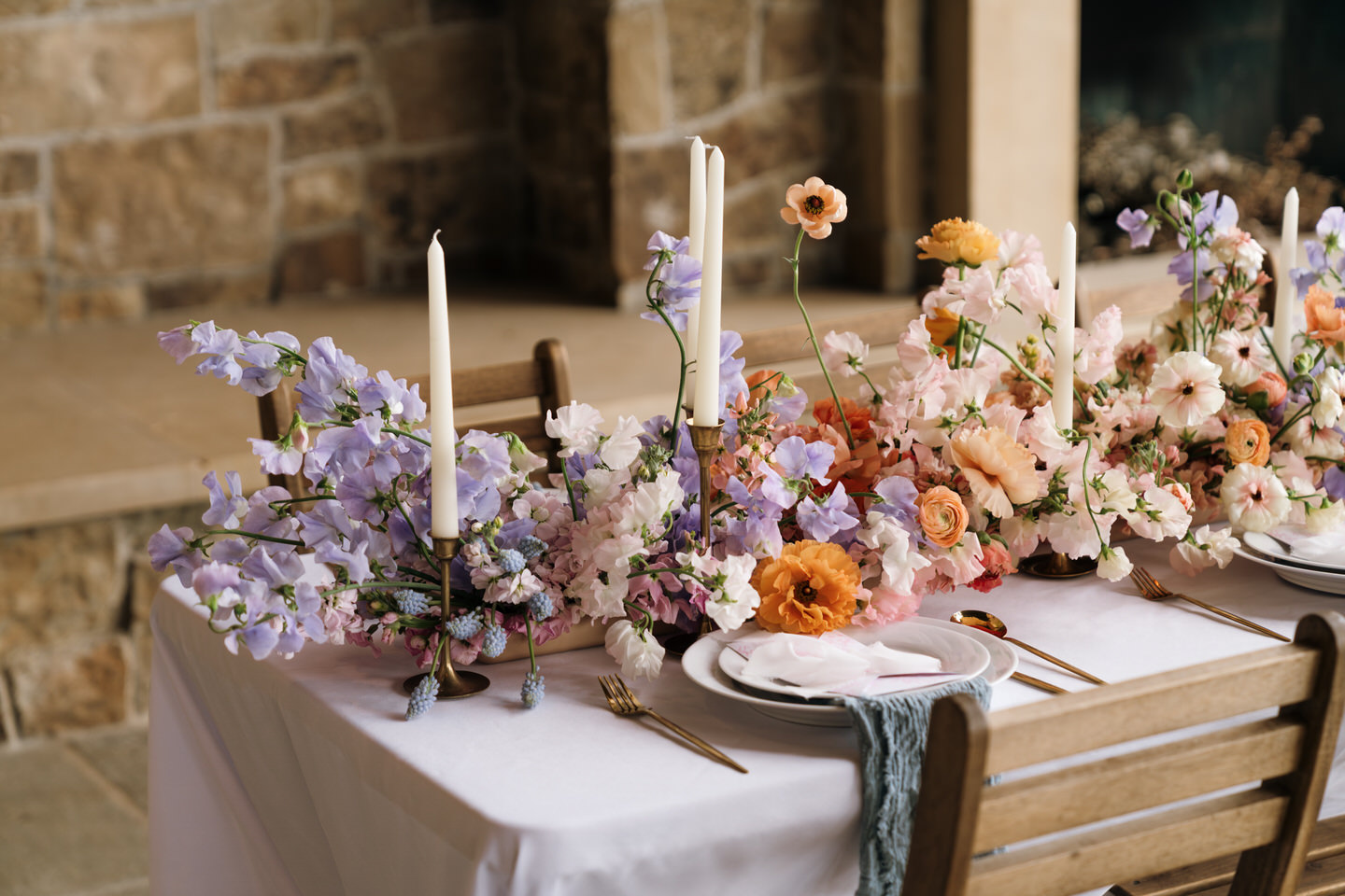 Tablescape at Chateau de Lis with colorful floral runner, gold flatware, and elevated spring details