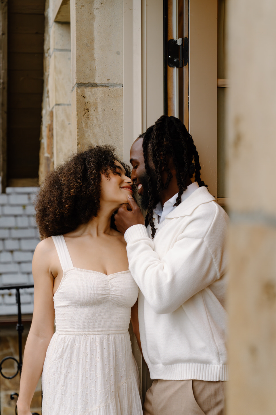 Couple looks into the distance on the balcony at the Chateau de Lis.
