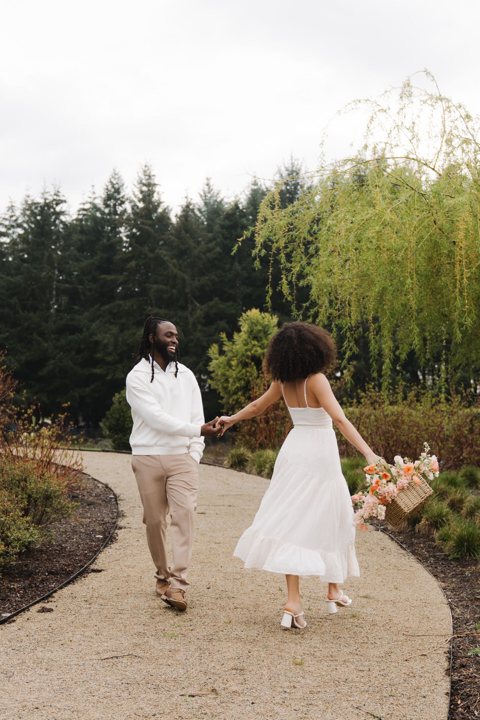 Couple walking together along the water’s edge, sharing conversation and laughter during their session.