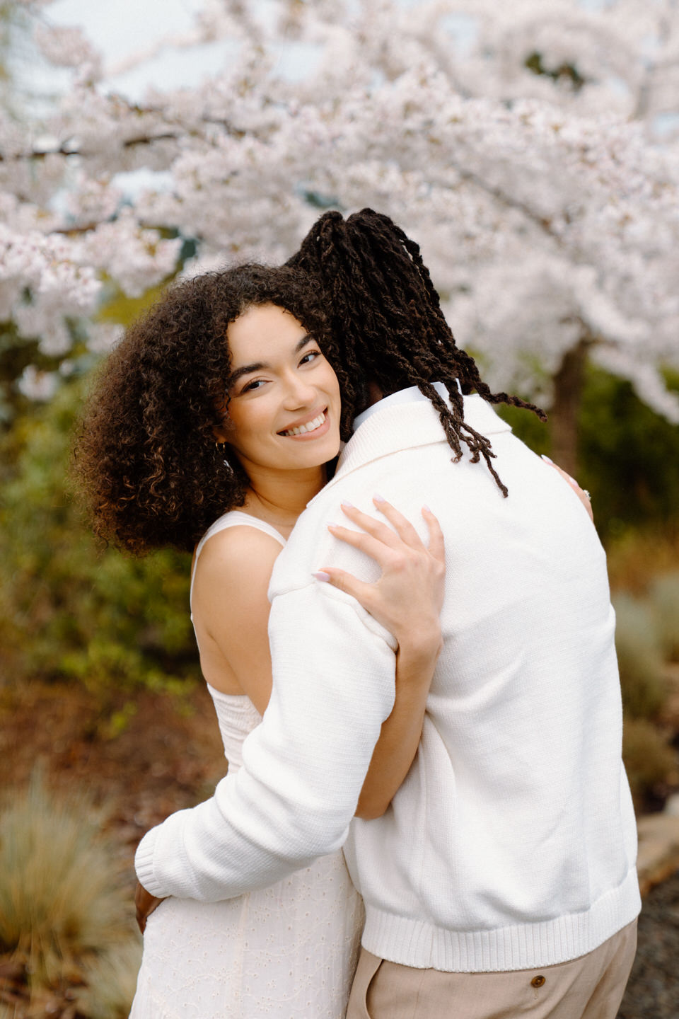 Joyful close-up of couple hugging at Chateau de Lis, showcasing natural smiles and relaxed spring engagement energy.