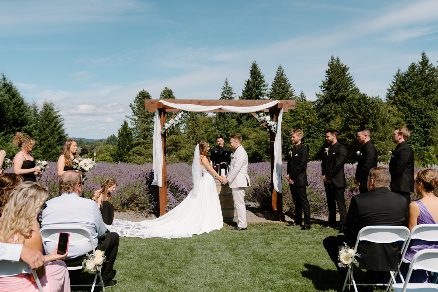 Hailey and Tyler exchanging vows with the lavender field behind them at Castle Rock Lavender Farm.