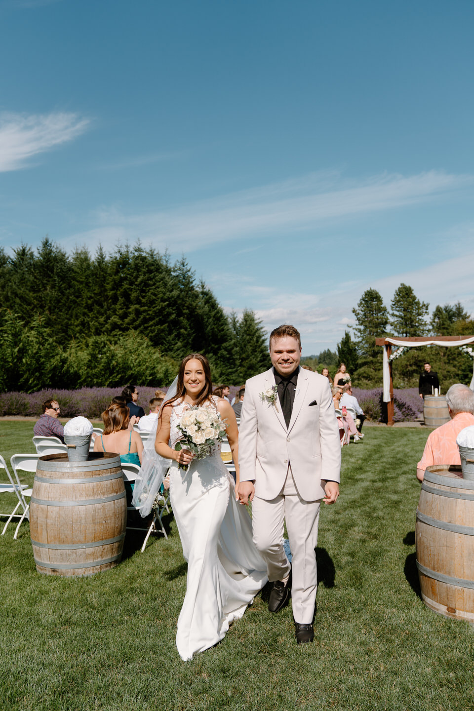 Hailey and Tyler walking back down the aisle smiling and holding hands.