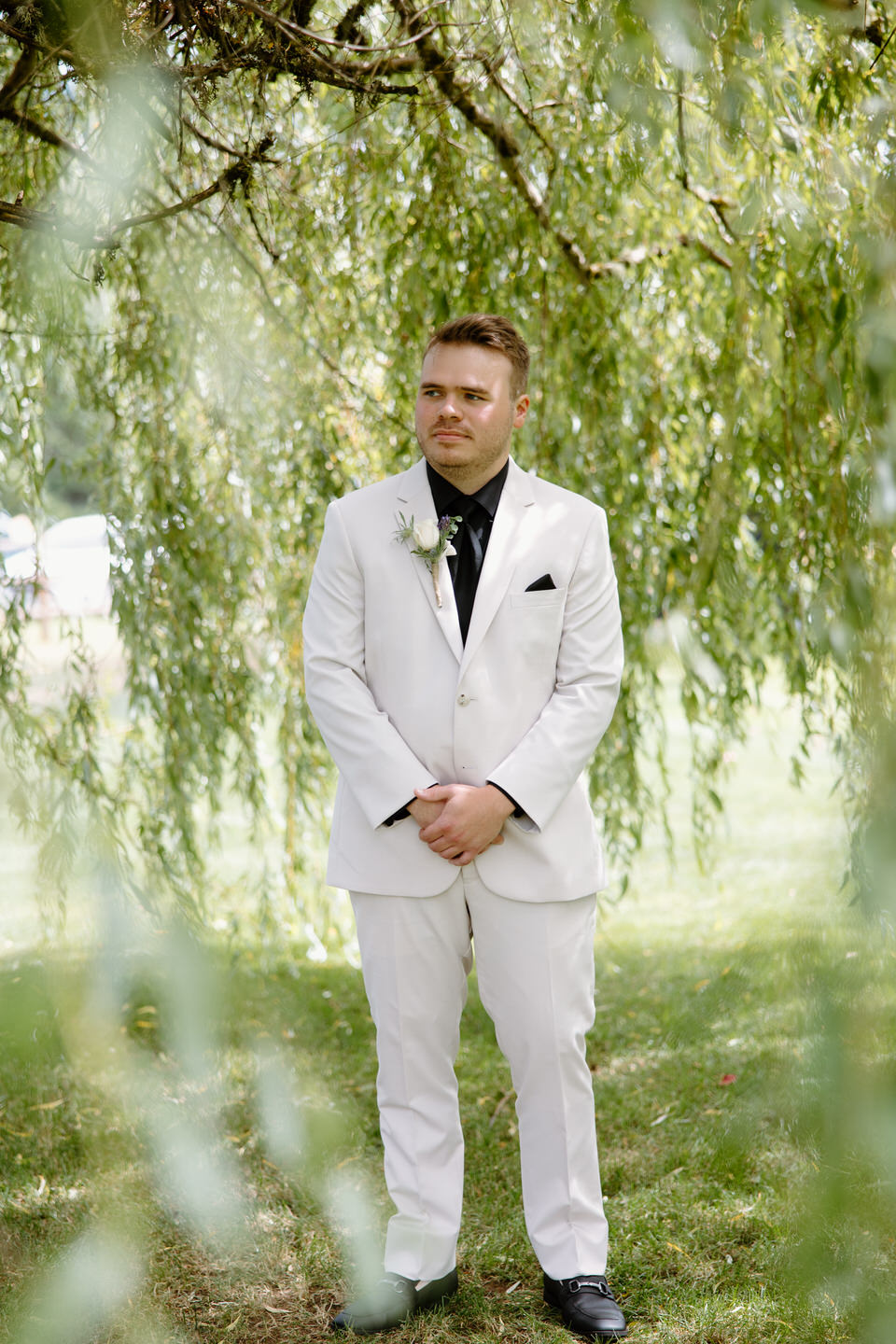 Tyler waiting under the willow tree before his first look.