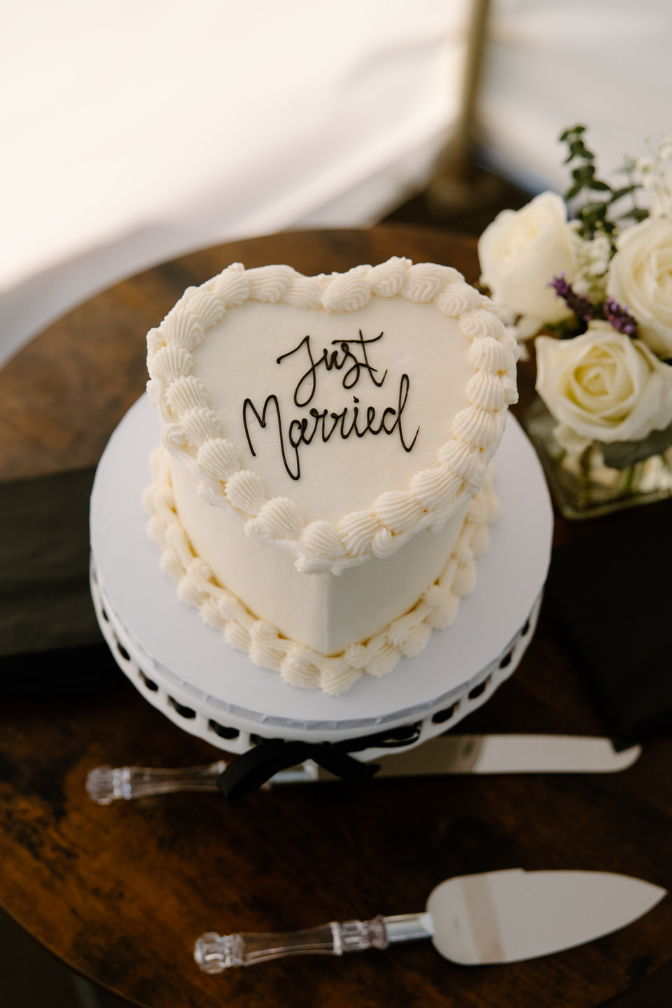 Heart-shaped white wedding cake reading "Just Married".