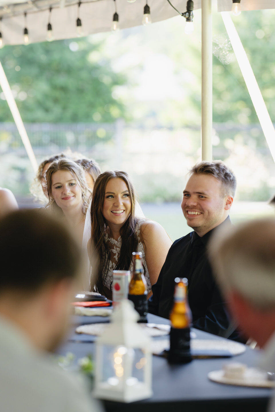 Bride and groom smiling and laughing at the reception table.