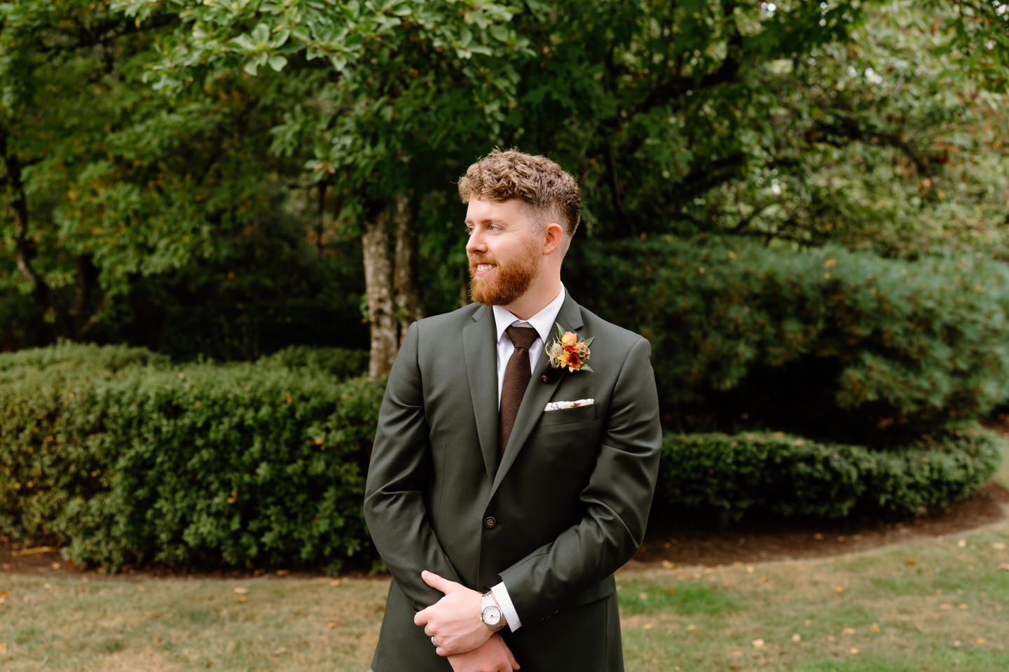 Groom portrait standing in lush greenery during an intimate Portland Oregon wedding celebration.