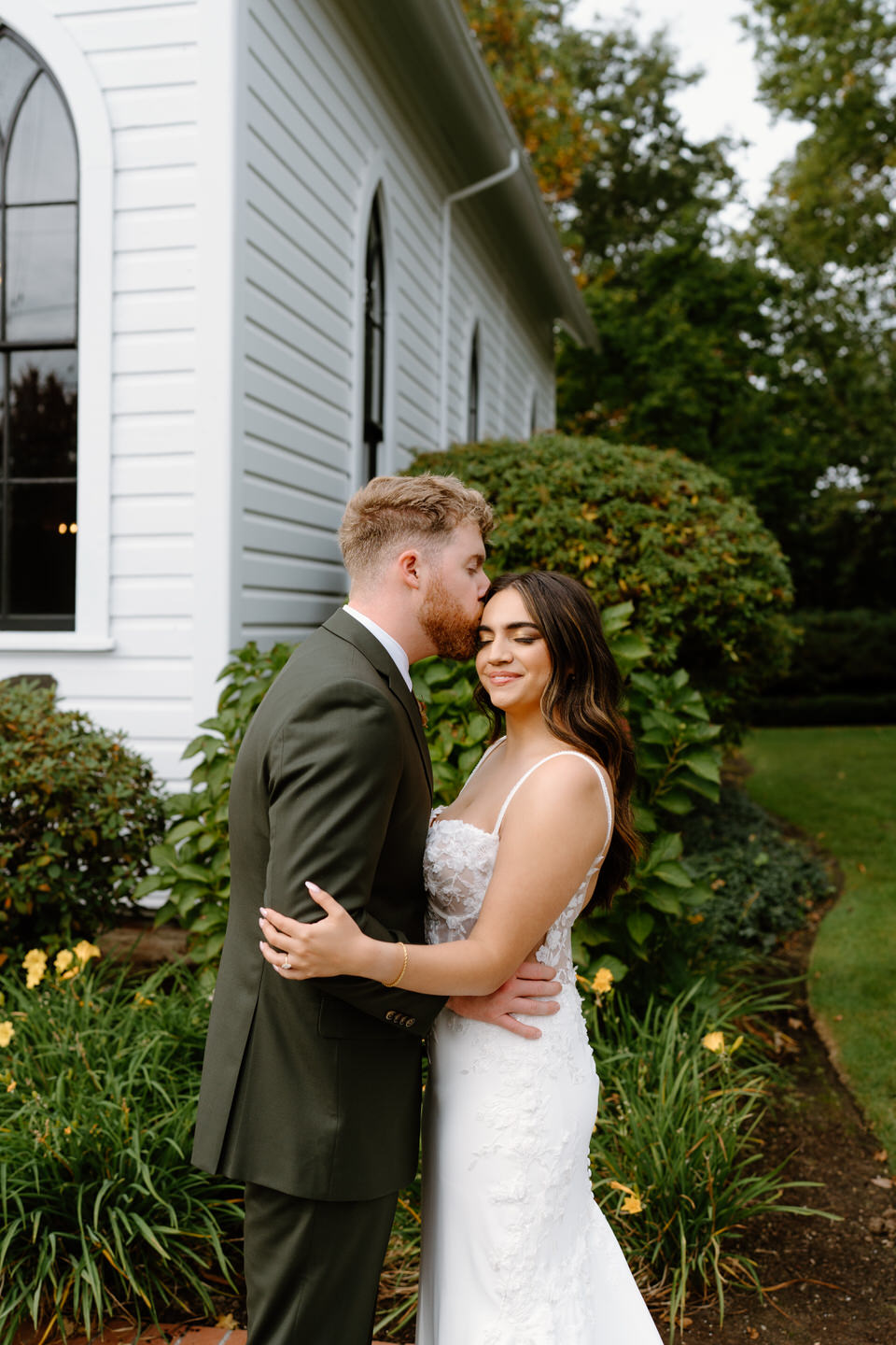 Bride and groom embracing beside the chapel gardens during a beautiful Oaks Pioneer Church wedding portrait session.