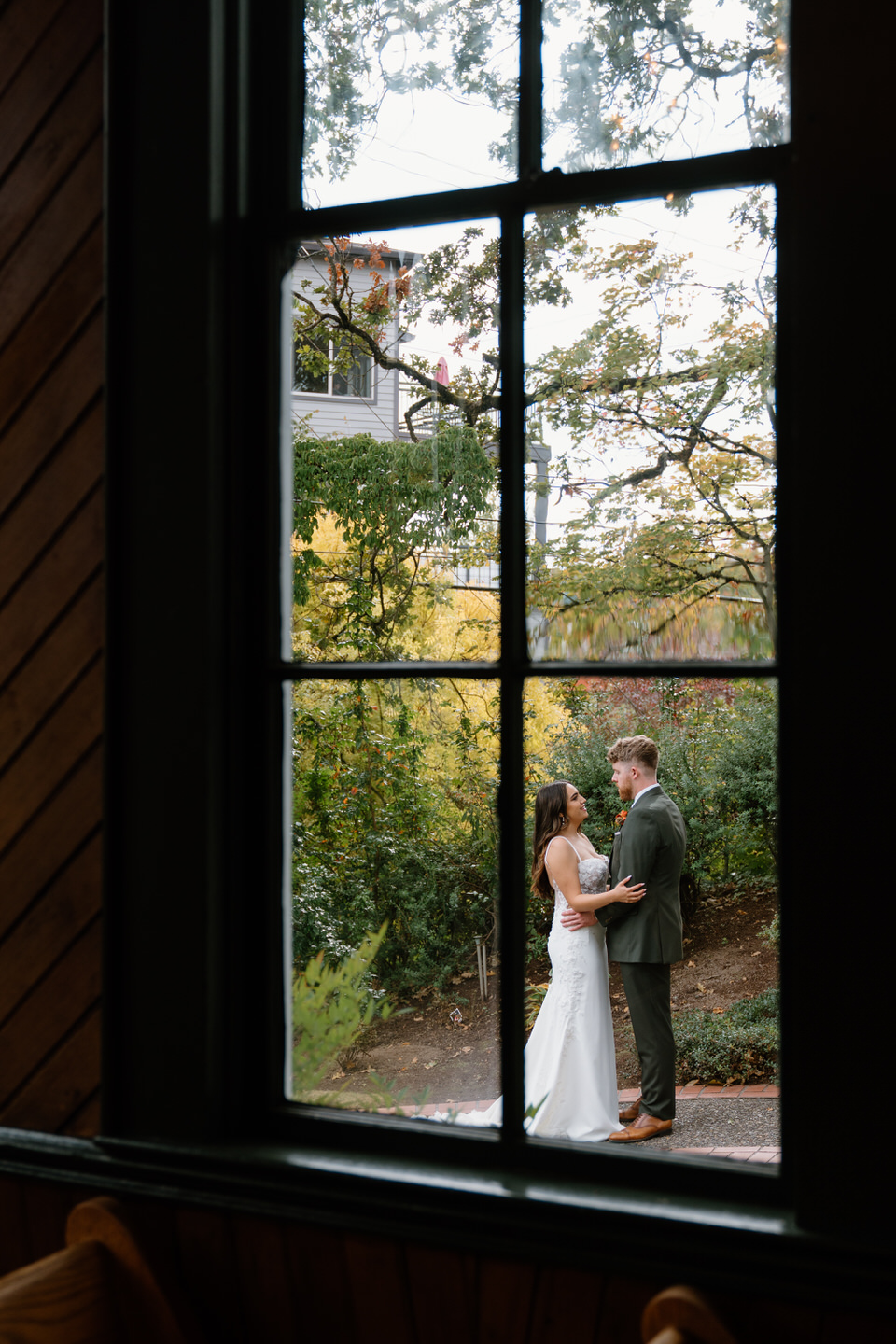 Bride and groom embrace outdoors beside the chapel after their romantic Oaks Pioneer Church wedding in Portland.
