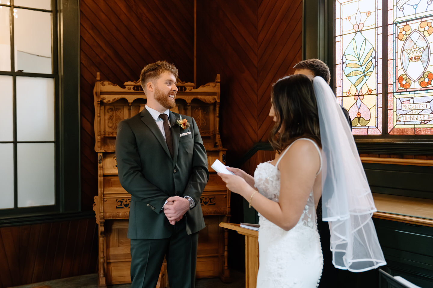 Bride reading her vows while groom smiles during an intimate ceremony at an Oaks Pioneer Church wedding in Portland.