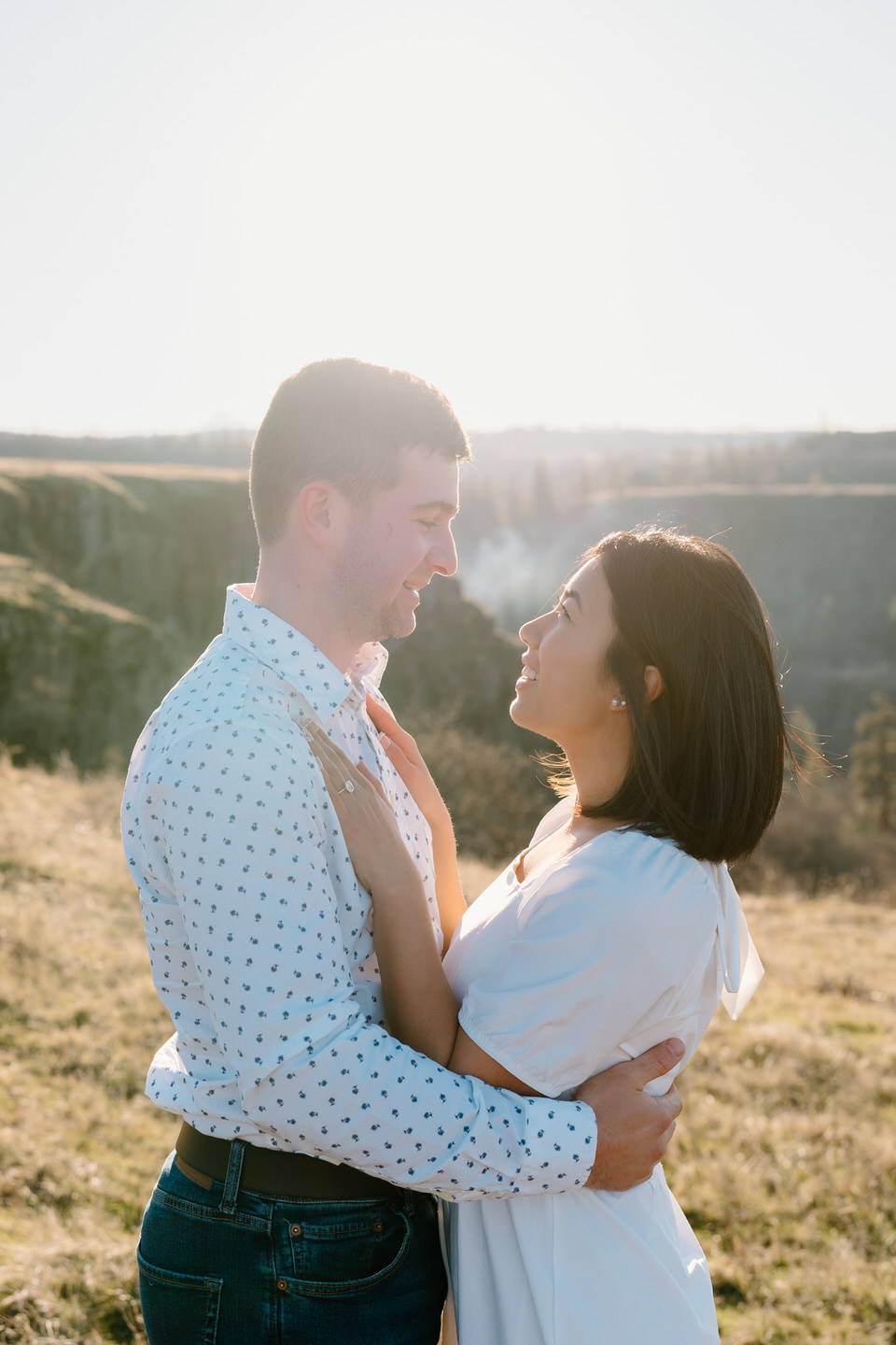 Couple faces each other, and Min places her hands on Alex's chest during engagement session at Rowena Crest.