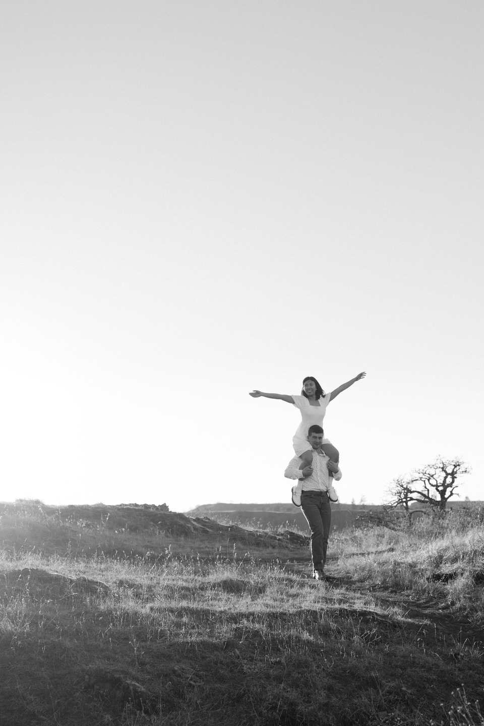 Min sits on Alex's shoulders, throwing her arms up in a carefree way.