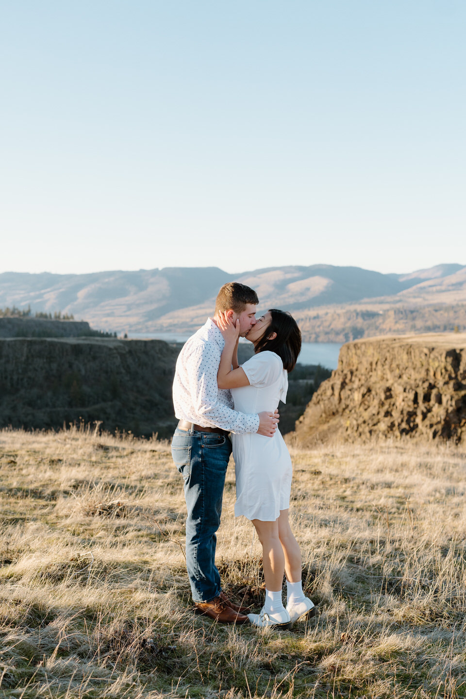 Couple pulled in for a kiss in front of the winter scene in the Columbia River Gorge.