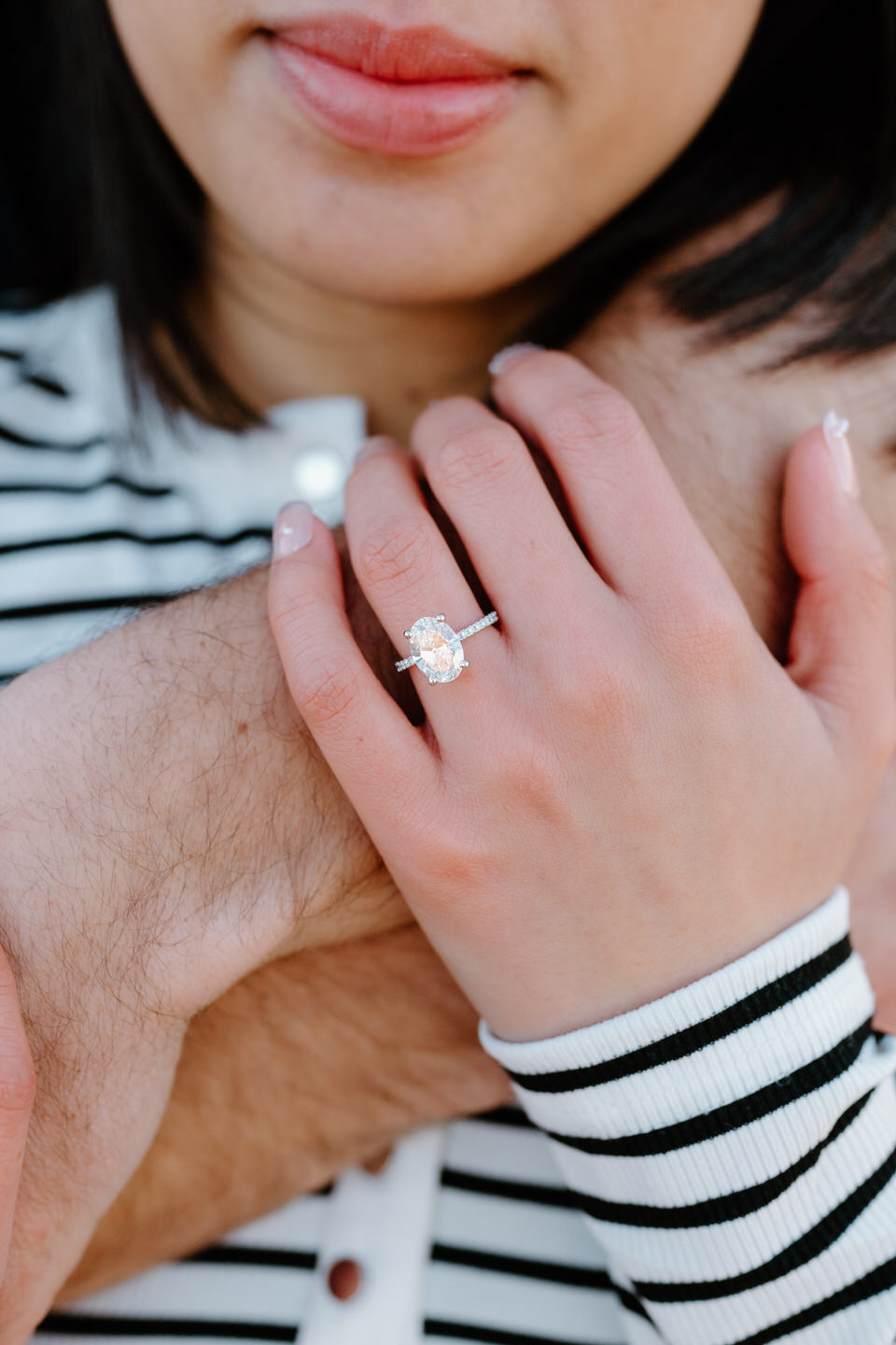 Oval cut engagement ring detail photo during couples photoshoot.