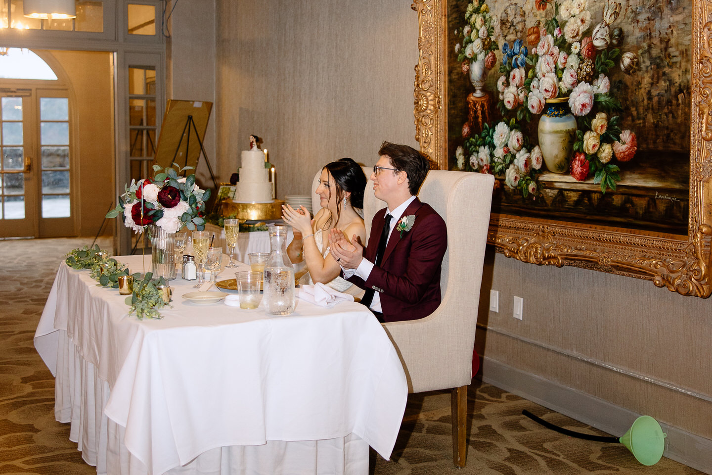 Bride and groom listen to toasts at their sweetheart table