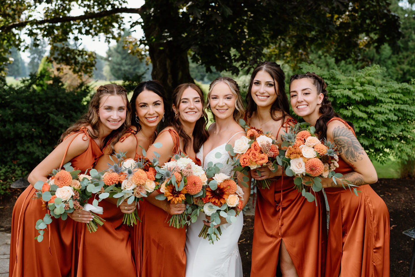 Bride and bridesmaids posing with bouquets in the garden at shadow hills country club