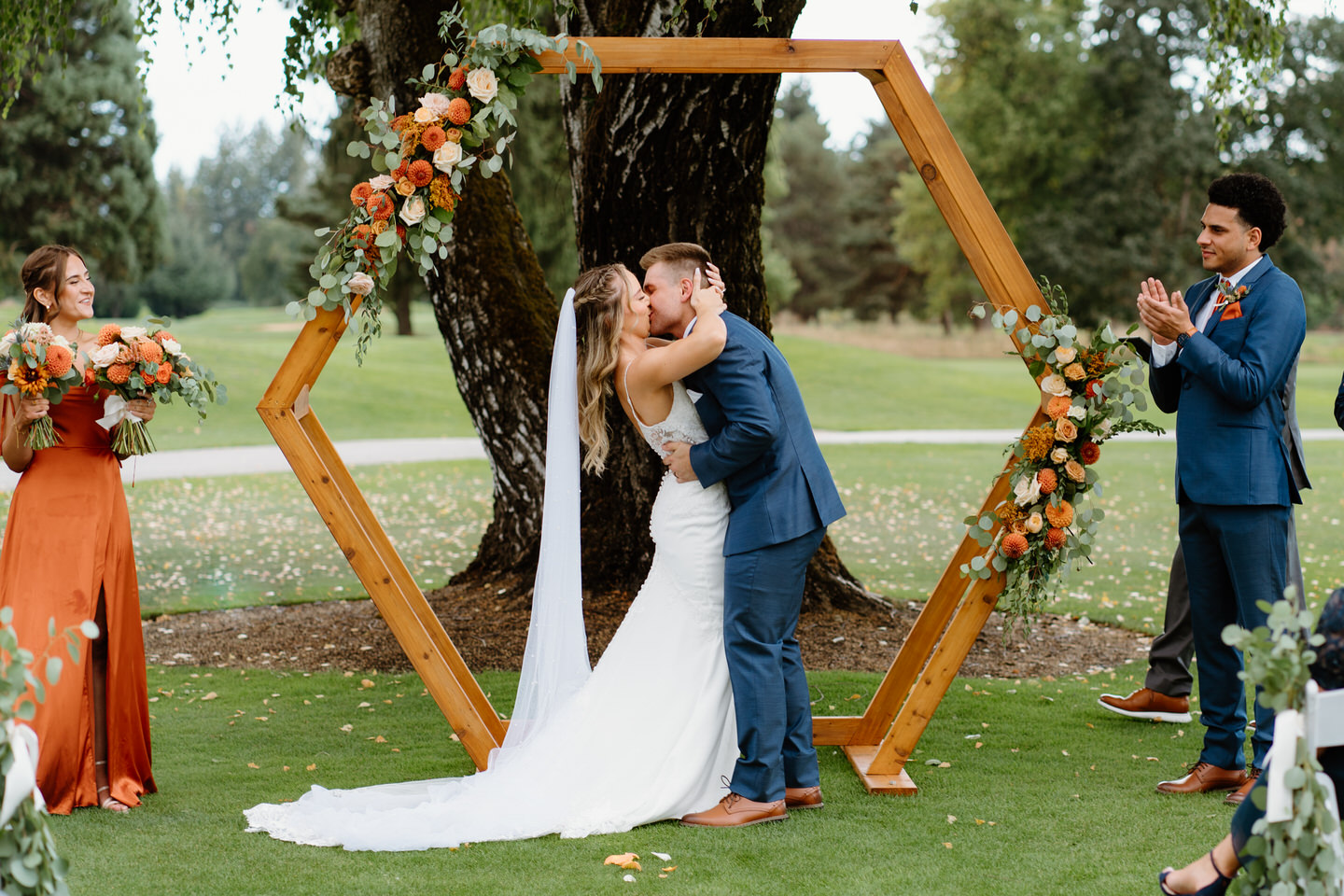 Bride and groom kiss as they are pronounced husband and wife under their hexagonal arch