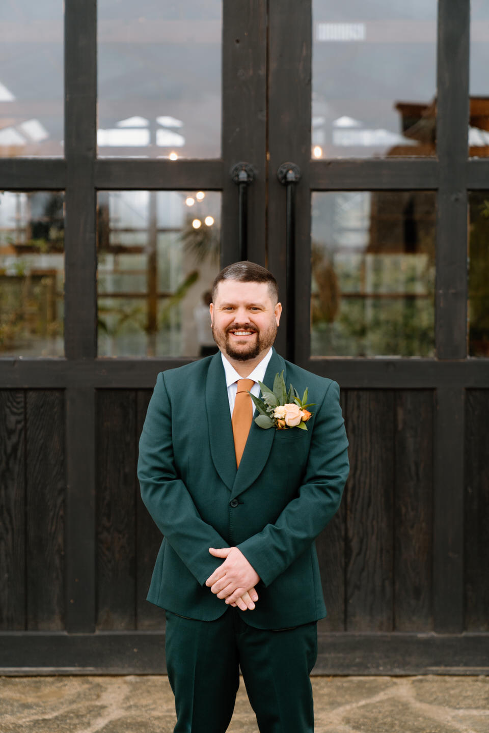 groom in green suit with orange tie