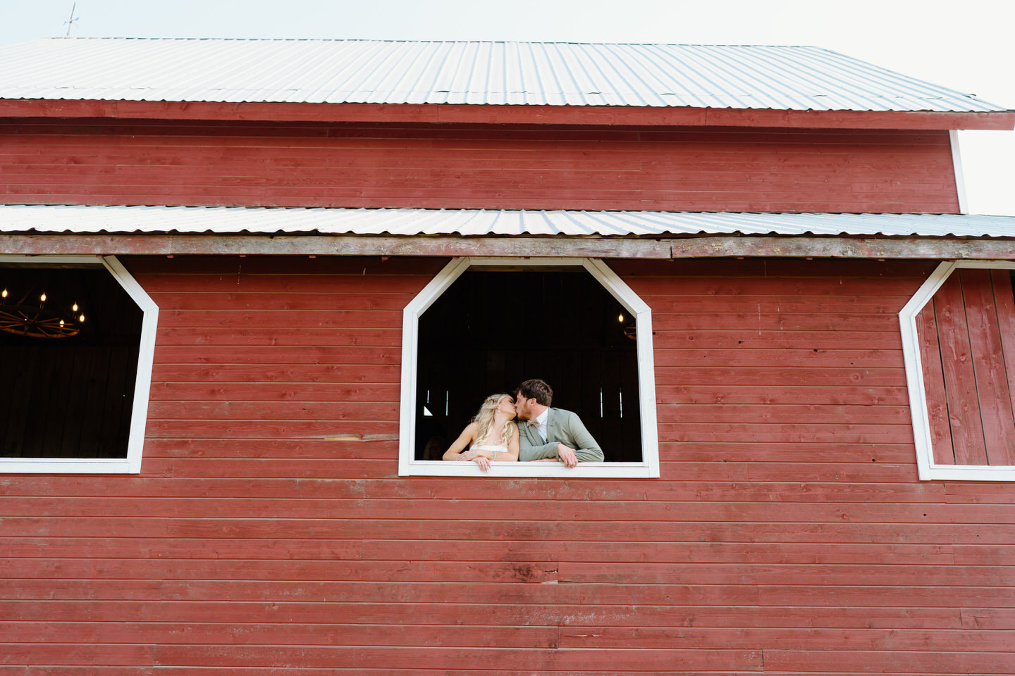 bride and groom kissing in barn at perryhill events