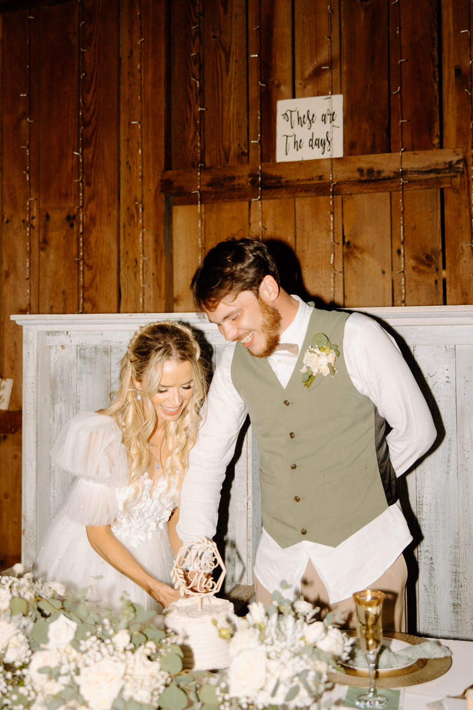 Cake cutting in a rustic barn wedding reception
