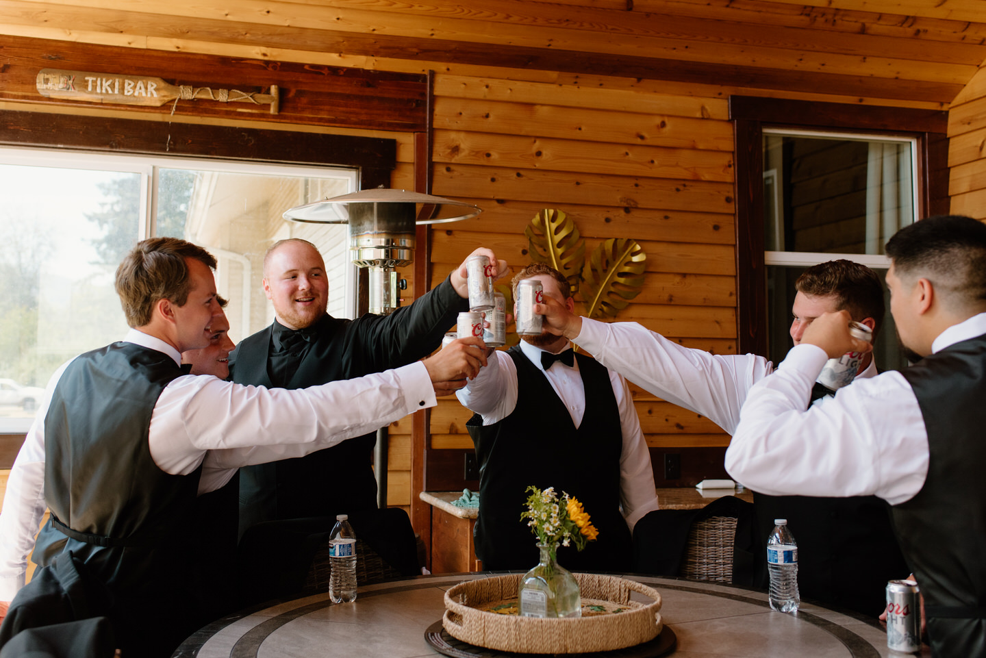 groom and groomsmen cheers their beers before wedding ceremony