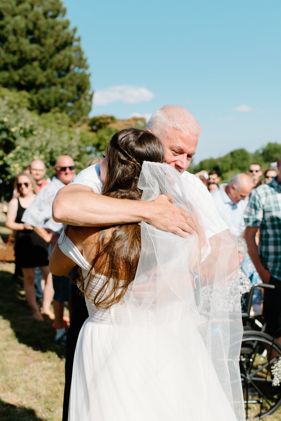 bride and dad share hug during wedding ceremony