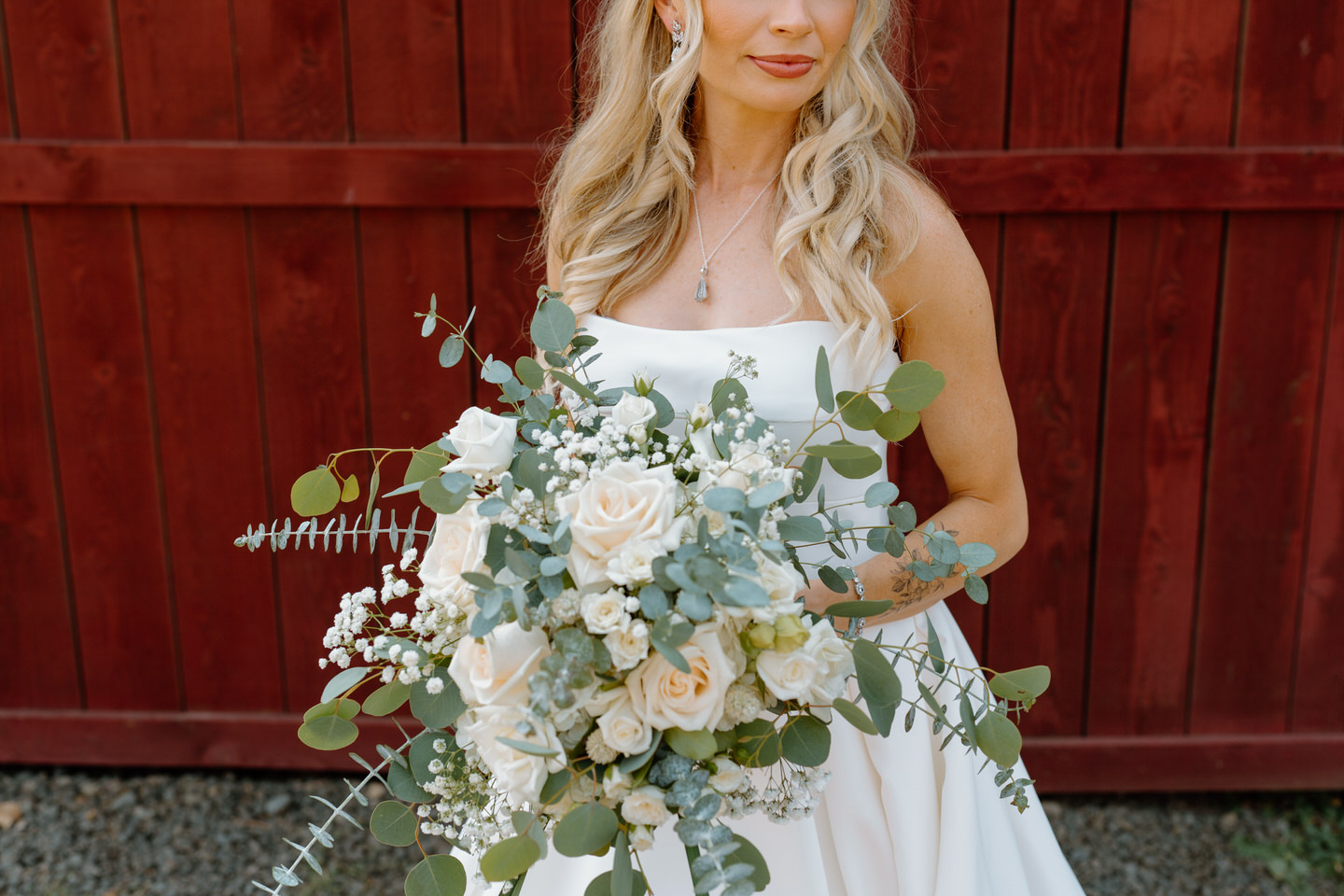 bridal bouquet with eucalyptus in front of rustic barn for wedding