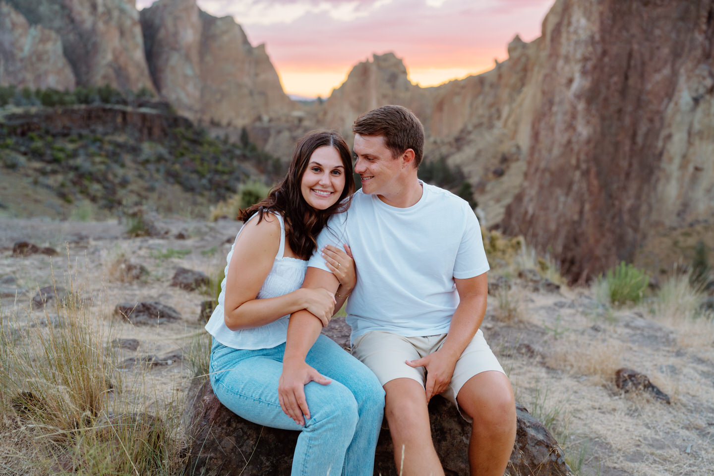 Couple smiling for engagement photos at Smith Rock