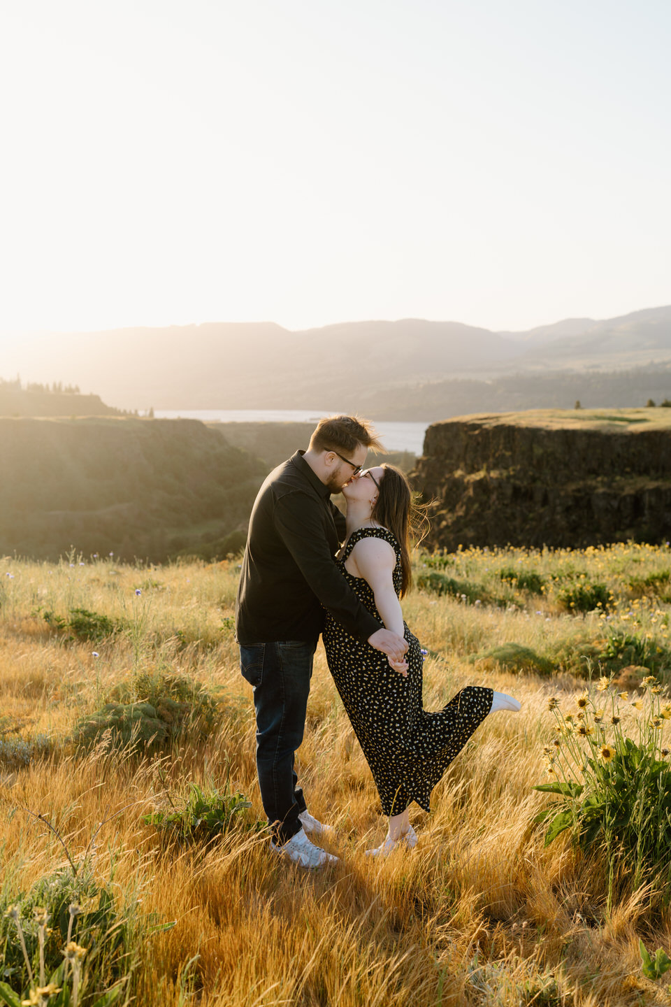couple kisses in a grassy field