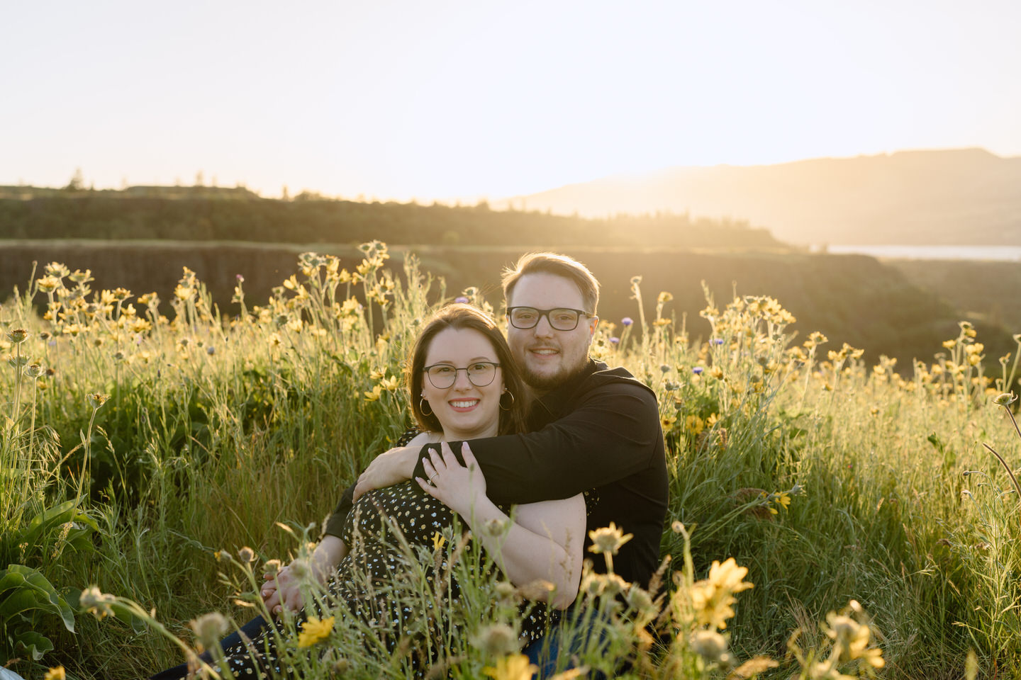 couple sitting and smiling in wildflower field