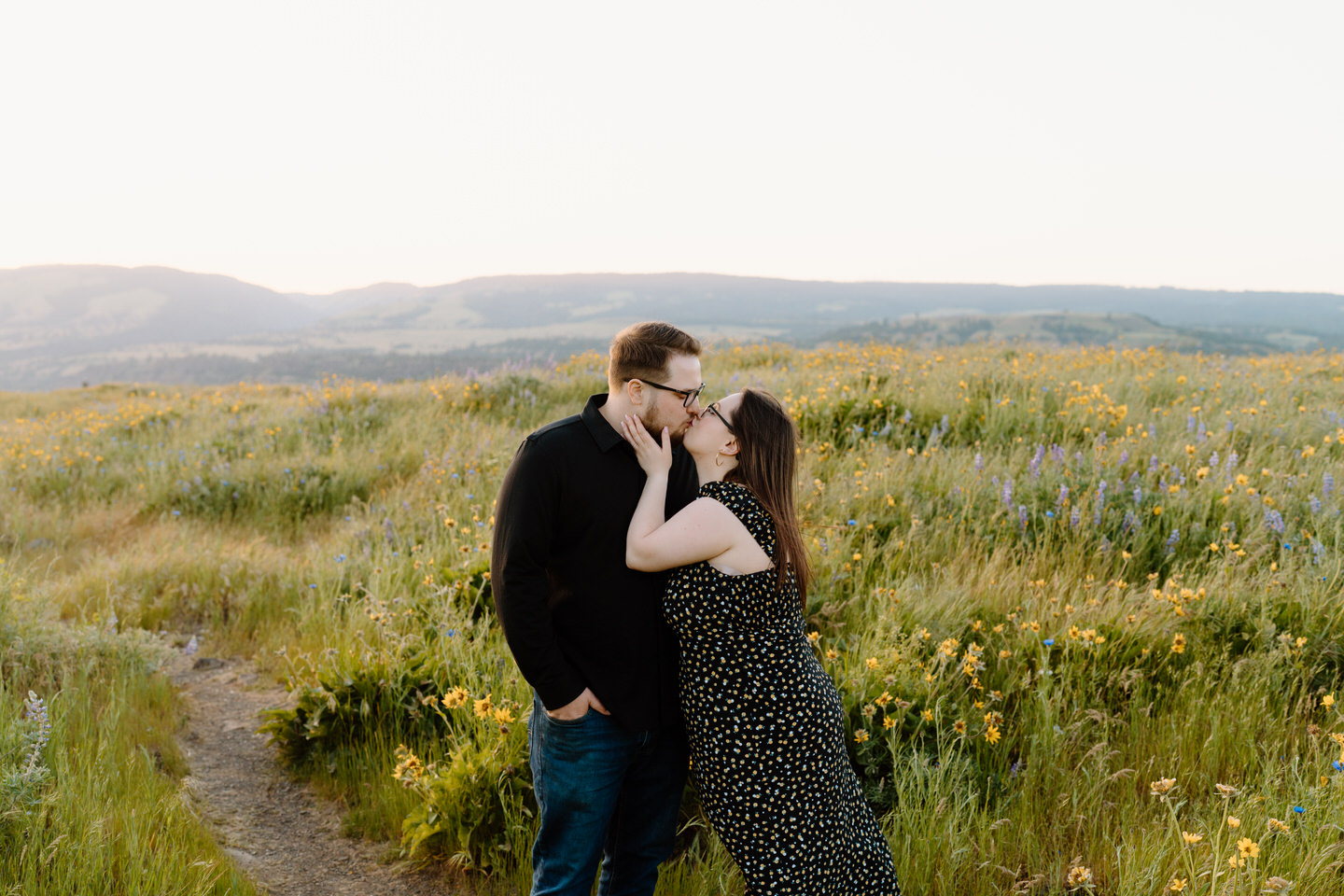 couple kisses in while in flower field during columbia river gorge engagement photos