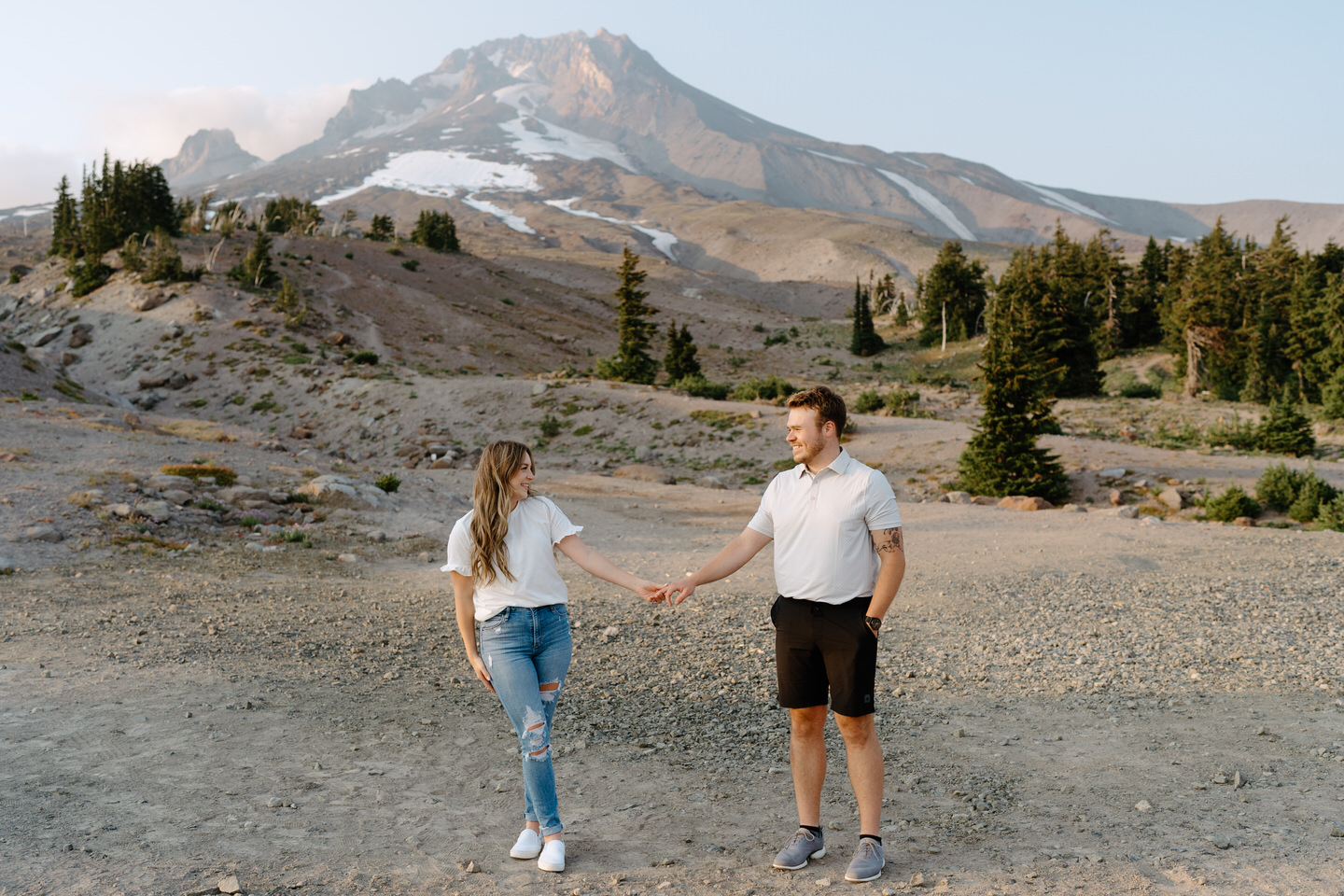 holding hands in front of mt hood at timberline