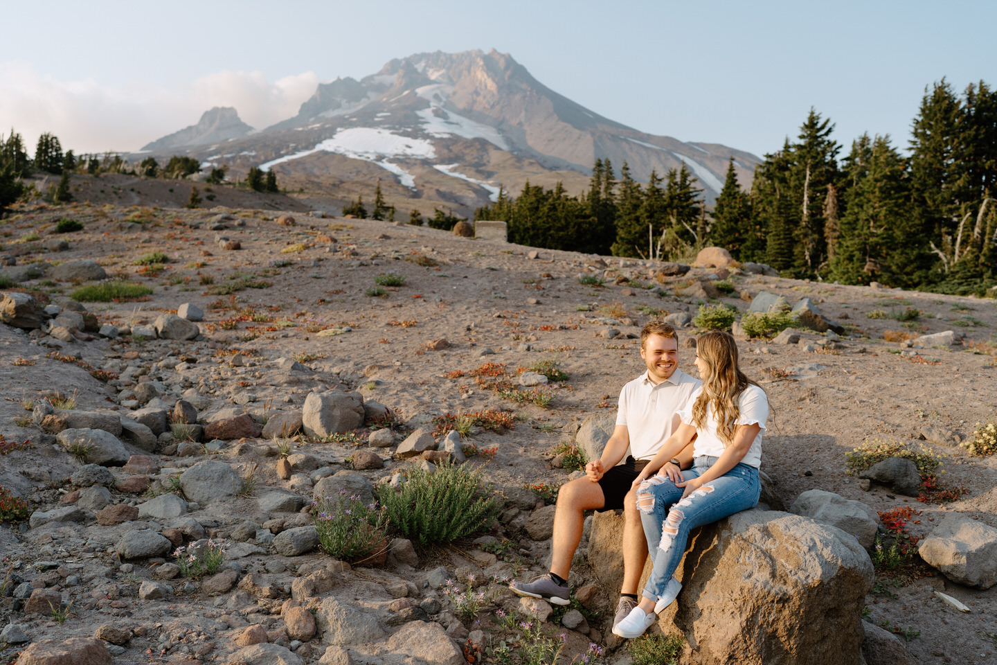 couple sitting on boulder for mt hood couples session
