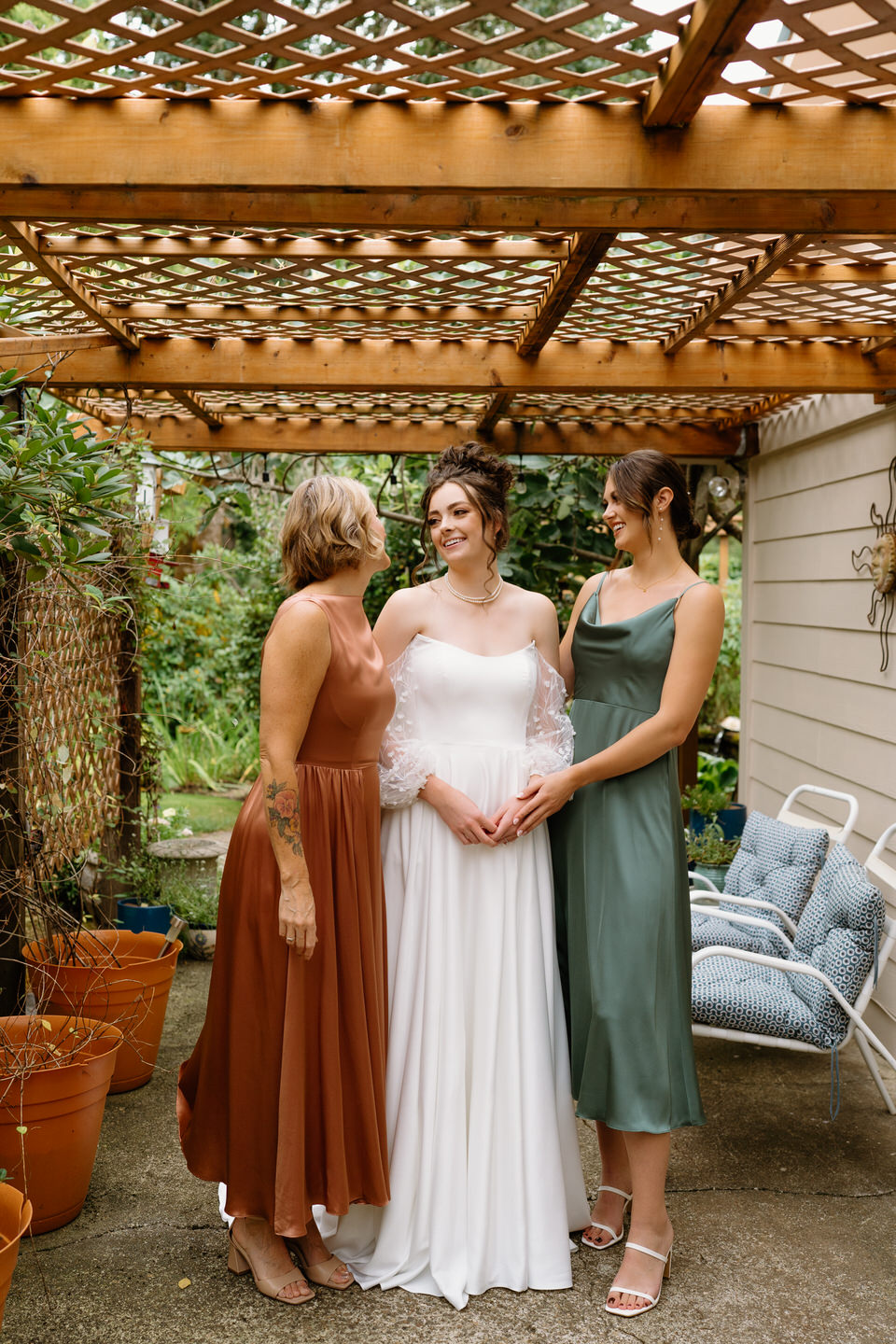 The bride, her mother, and her sister share a moment together before the wedding ceremony.