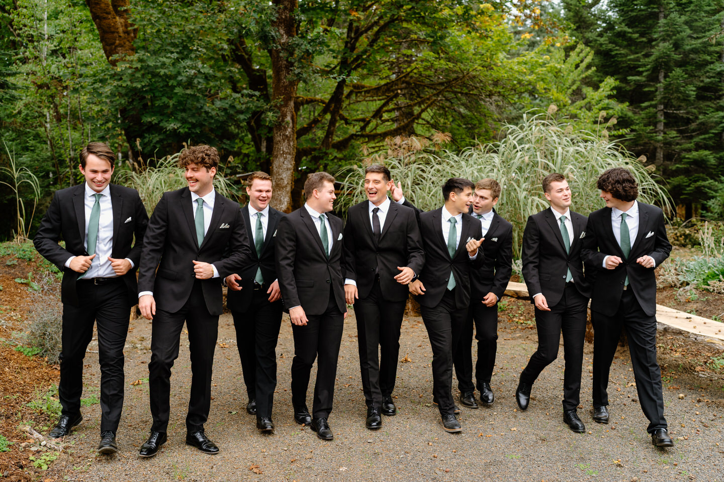 Groom and groomsmen walk together before wedding ceremony at Navarra Gardens.