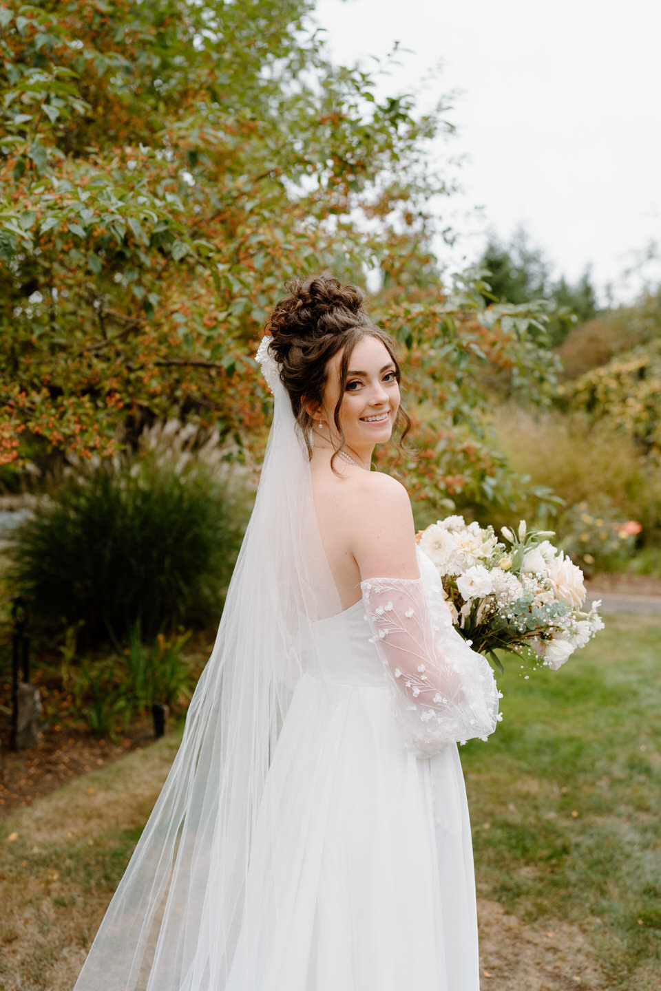 Bride looks over her shoulder with her veil-bow in her hair.