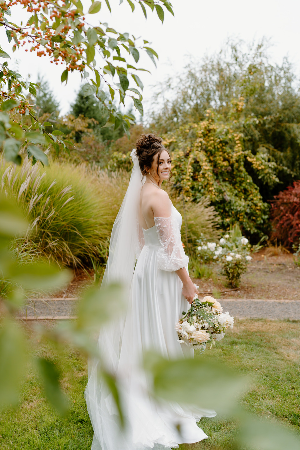 Bride in her Pandora by Truvelle wedding dress for a fall wedding at Navarra Gardens in Oregon.