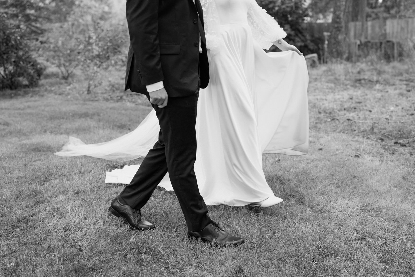 Black and white image of couple's legs as they walk through Navarra Gardens.