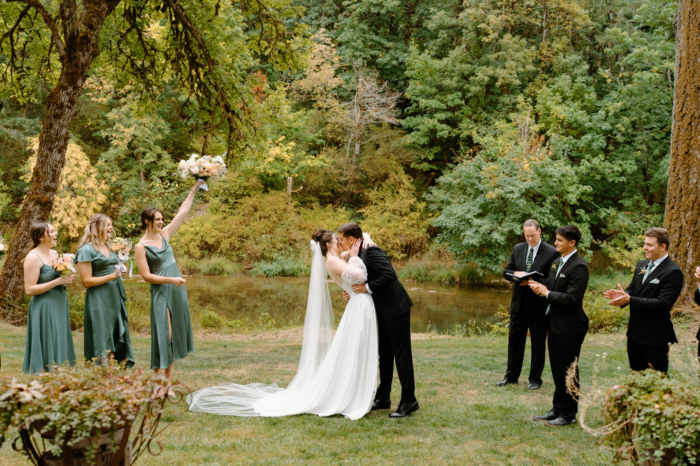 Bride and groom's first kiss as a married couple on the lawn at Navarra Gardens.