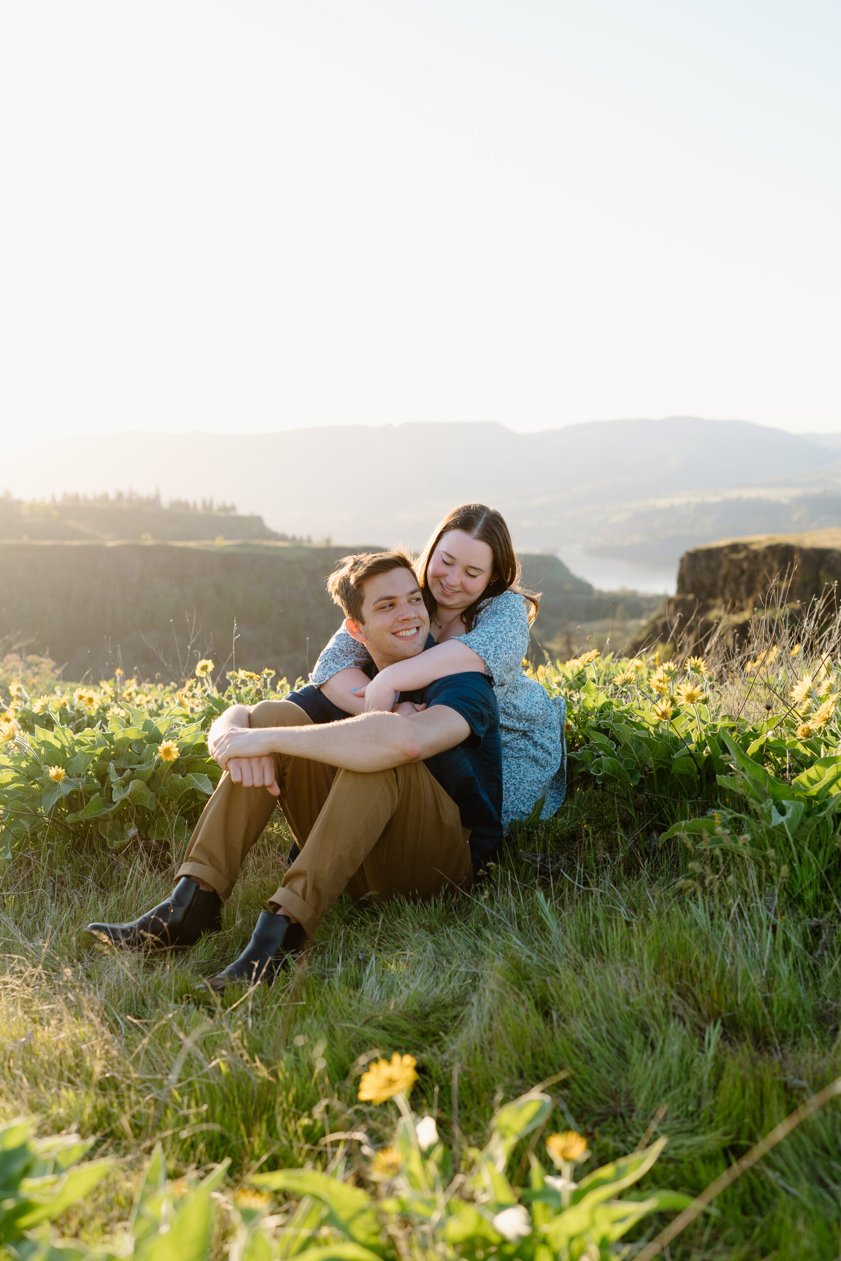 Couple sitting in the yellow wildflowers at Tom McCall Preserve in the Columbia Gorge.