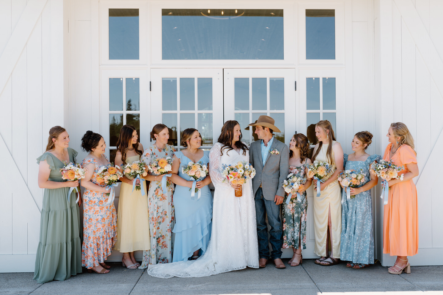 Mismatched bridesmaid dresses with green, yellow, blue, and orange colors.