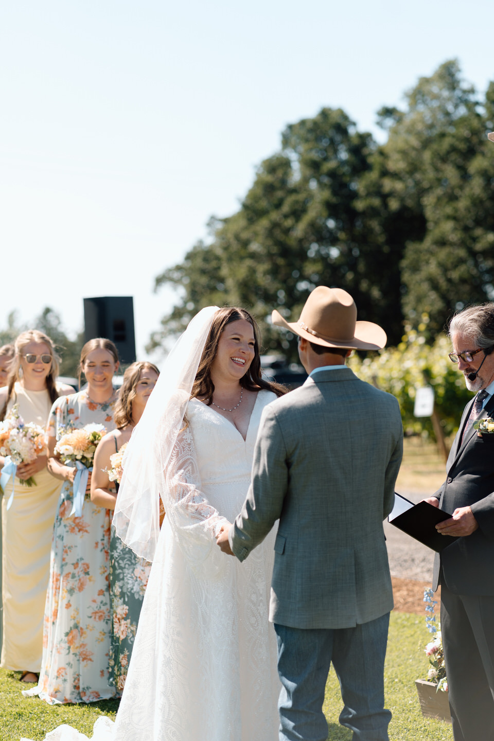 Bride and groom exchange vows during wedding ceremony in vineyard