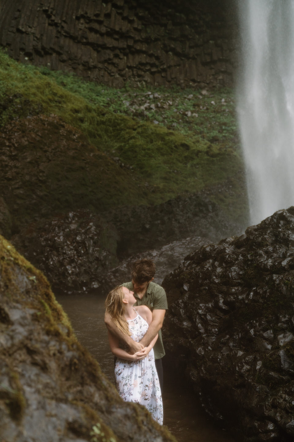 Couples photos beneath waterfall in the PNW.