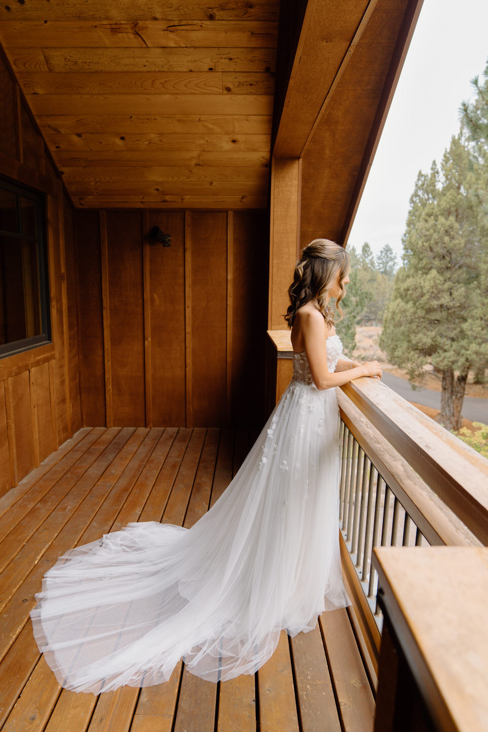 Bride looking over balcony at Aspen Lakes Golf Course wedding